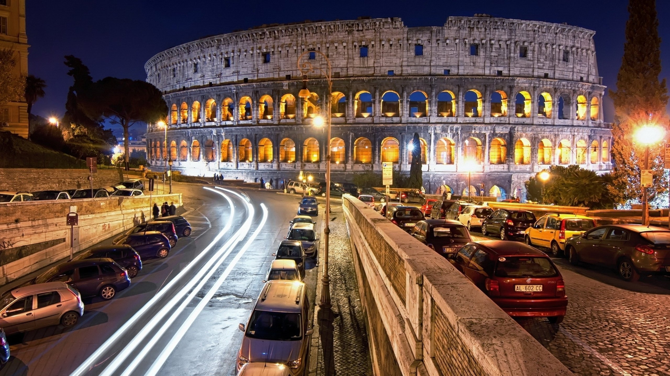 Cars on Road Near Brown Concrete Building During Night Time. Wallpaper in 2560x1440 Resolution