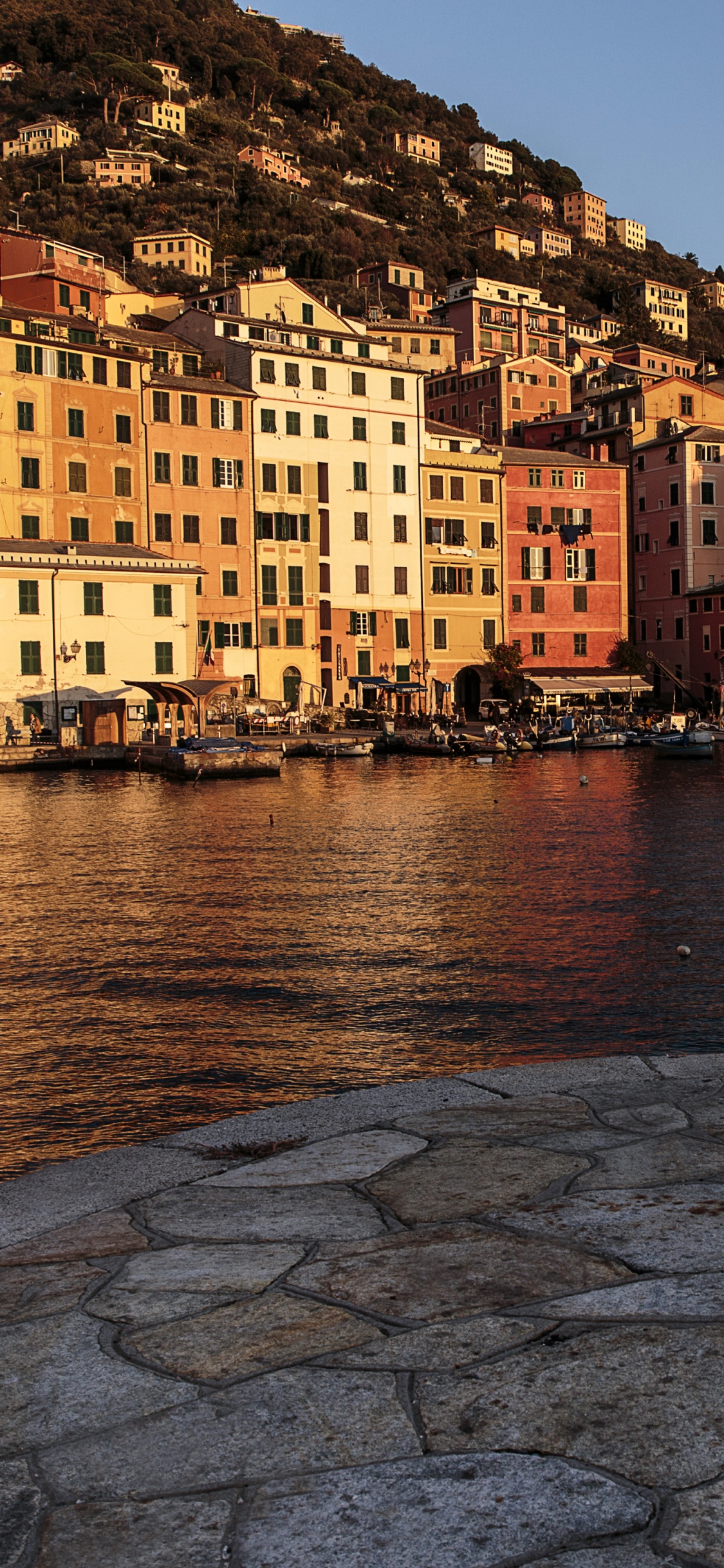 People Walking on Sidewalk Near Body of Water During Daytime. Wallpaper in 1125x2436 Resolution