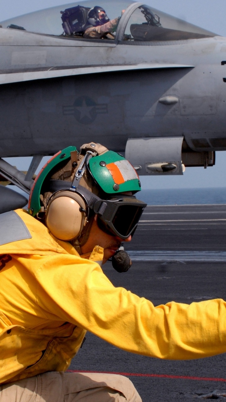Homme en Veste Jaune et Casque à Cheval Sur un Avion à Réaction Gris. Wallpaper in 720x1280 Resolution