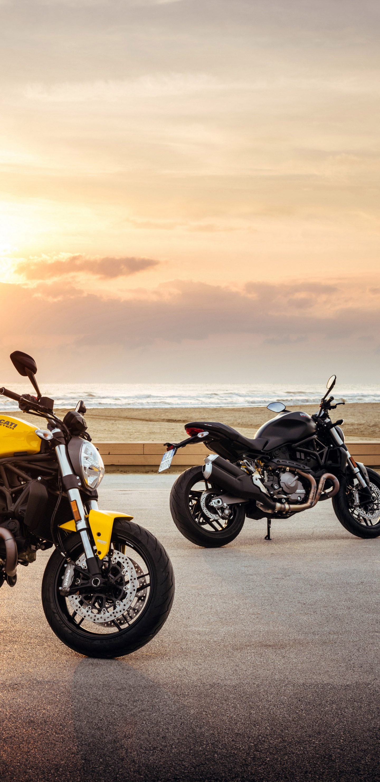 Gelbes Und Schwarzes Cruiser-Motorrad Auf Grauer Asphaltstraße Bei Sonnenuntergang. Wallpaper in 1440x2960 Resolution