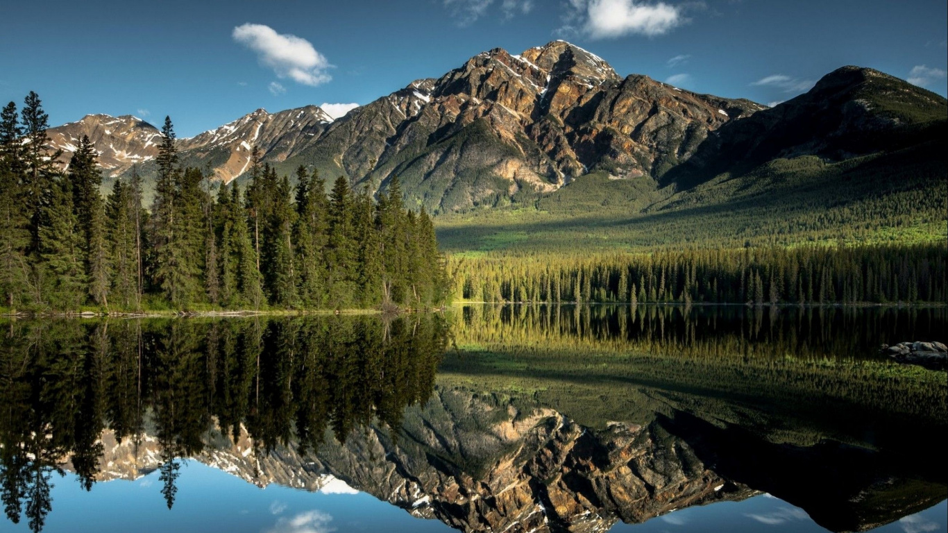 Green Grass Field Near Lake and Mountain. Wallpaper in 1366x768 Resolution