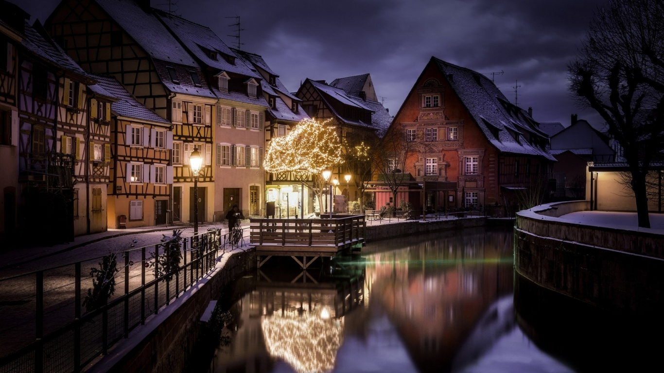 Edificio de Hormigón Marrón y Negro Junto al Río Durante la Noche. Wallpaper in 1366x768 Resolution