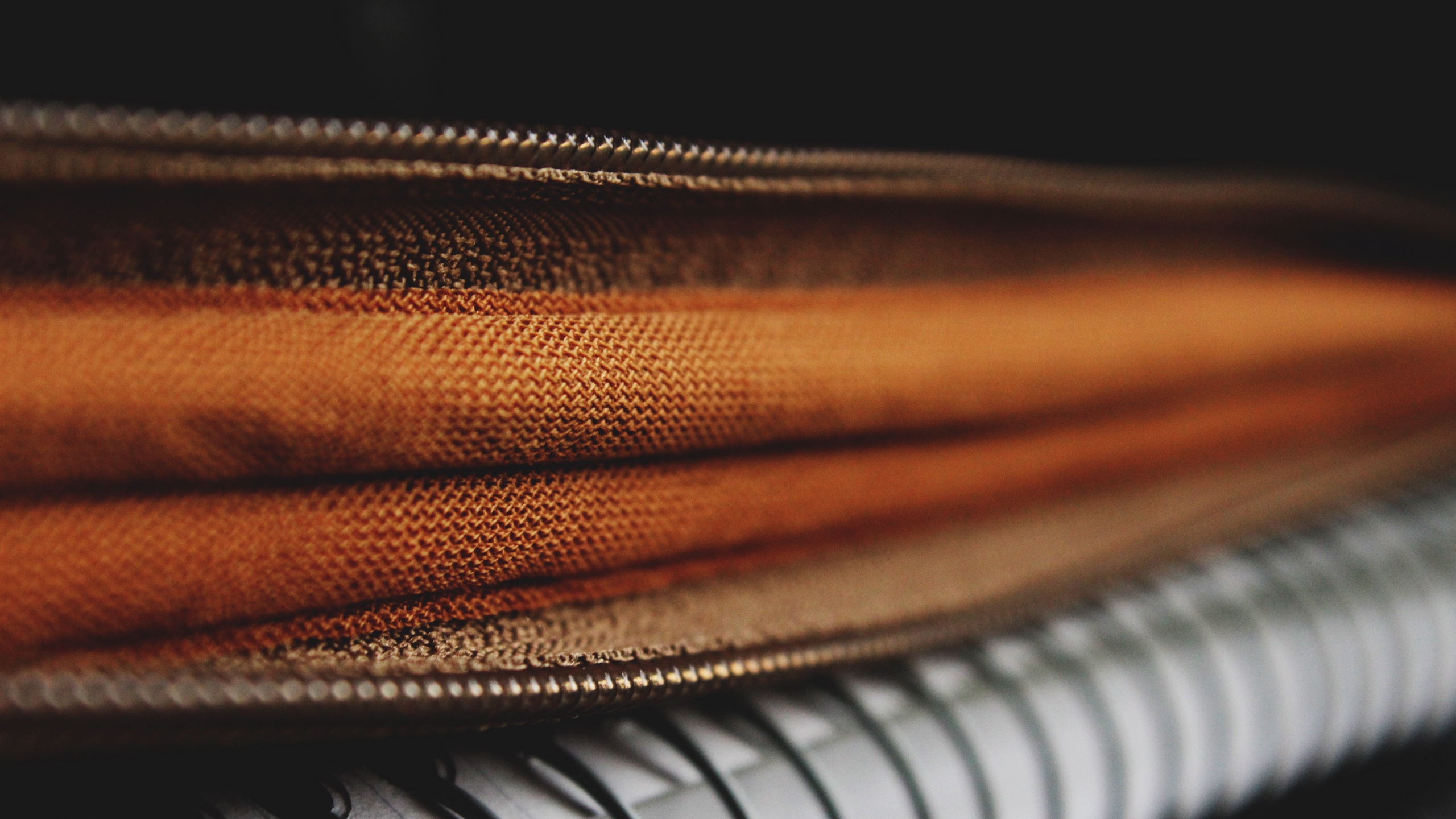 Brown Leather Zip Bag on White and Black Piano. Wallpaper in 2560x1440 Resolution