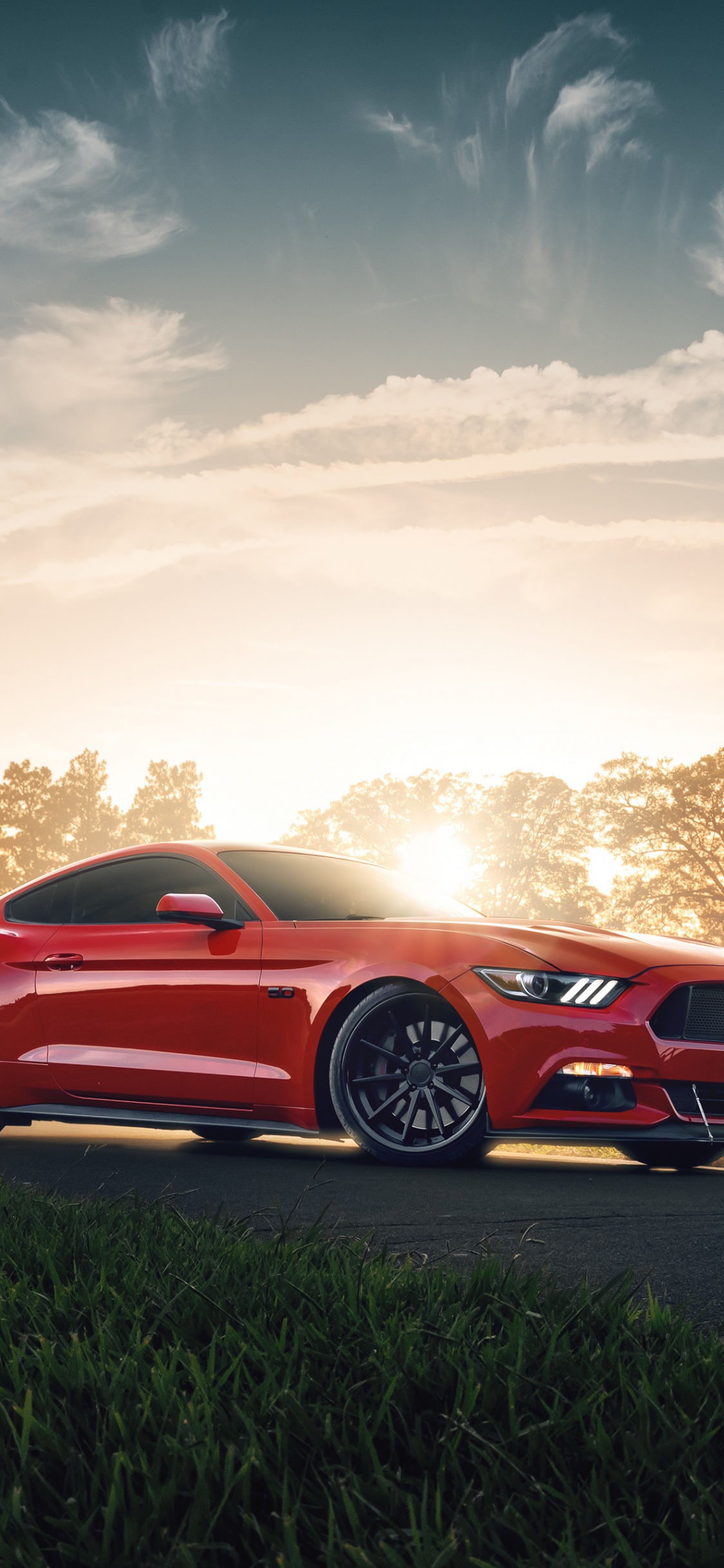 Rotes Coupe Unterwegs Bei Sonnenuntergang. Wallpaper in 1125x2436 Resolution