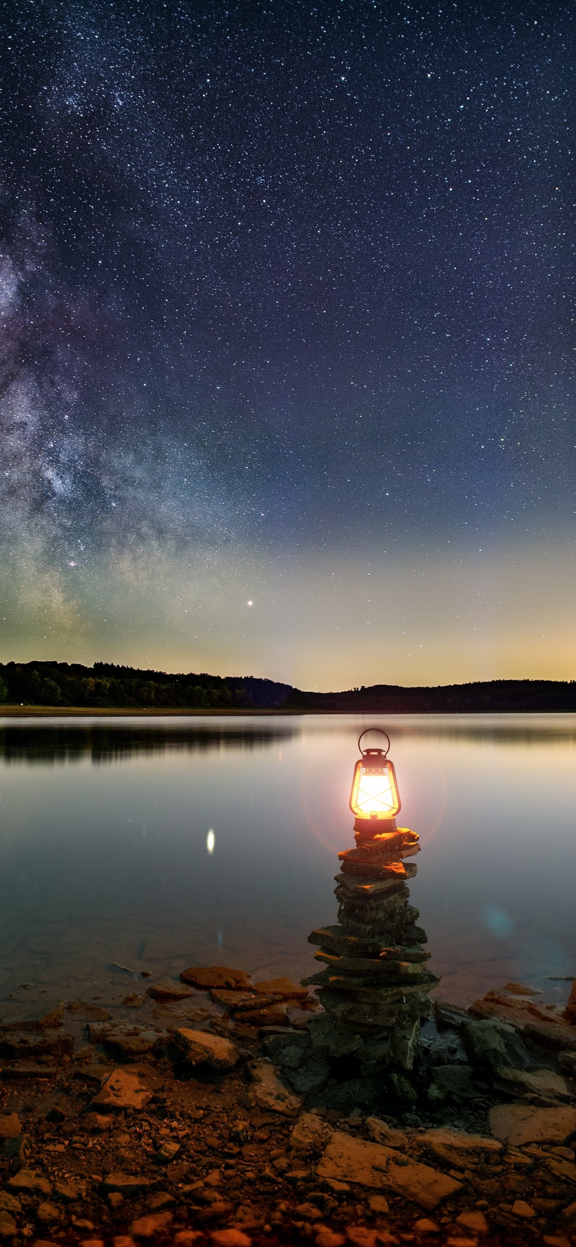 Body of Water Near Mountain During Night Time. Wallpaper in 1125x2436 Resolution