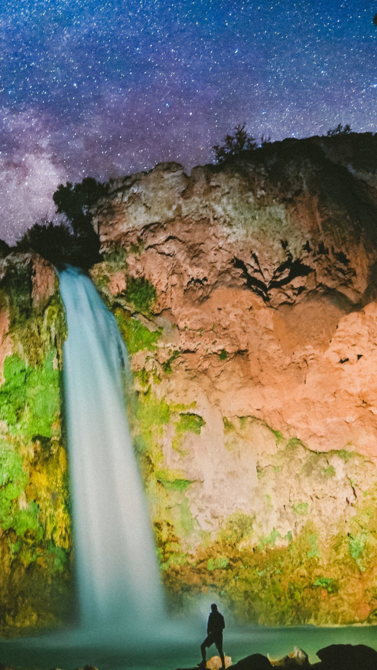 Person Standing on Rock Formation Under Blue Sky During Daytime. Wallpaper in 750x1334 Resolution