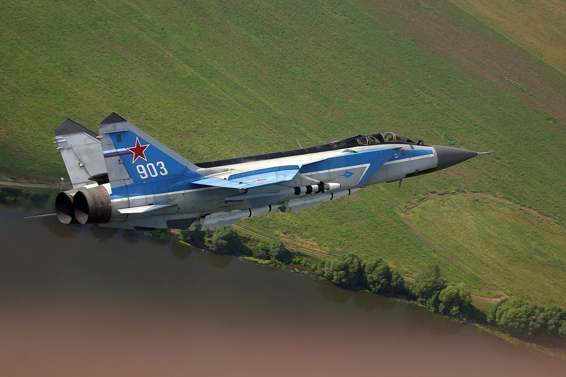 Blue and White Jet Plane Flying Over Green Grass Field During Daytime. Wallpaper in 3072x2048 Resolution