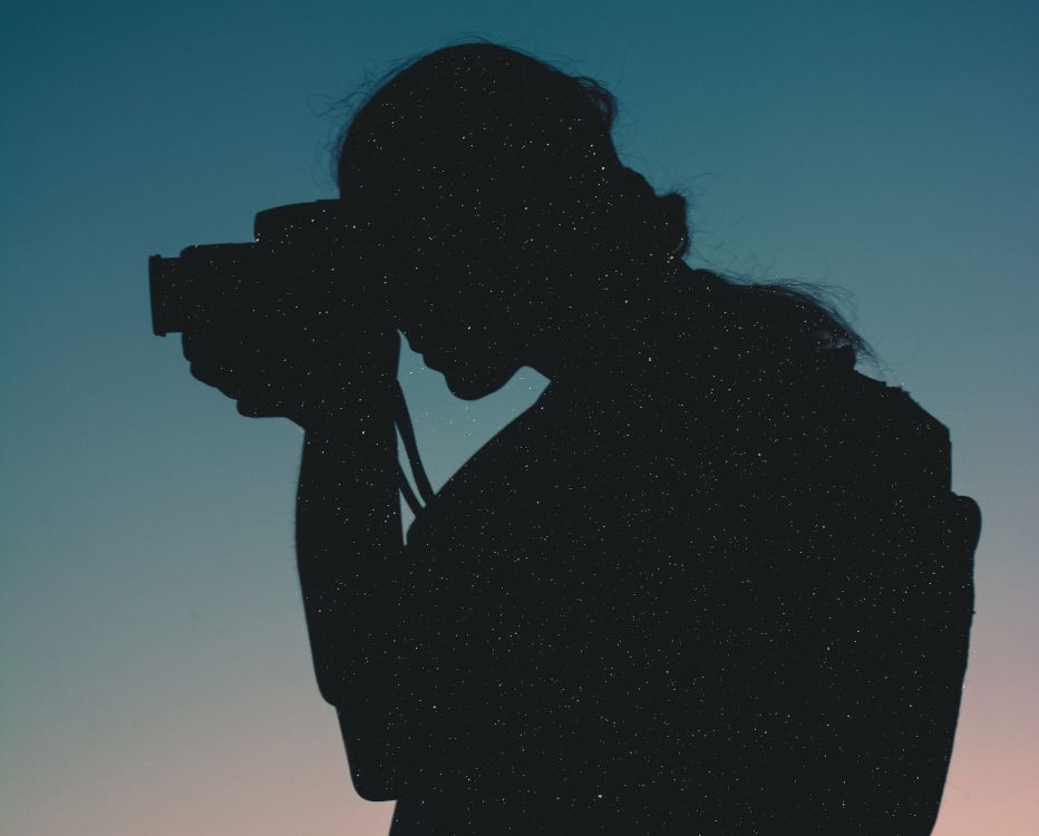 silhouette of woman holding camera