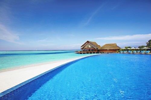 Image brown wooden house on blue sea under blue sky during daytime