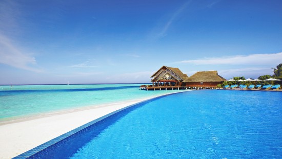 Image brown wooden house on blue sea under blue sky during daytime