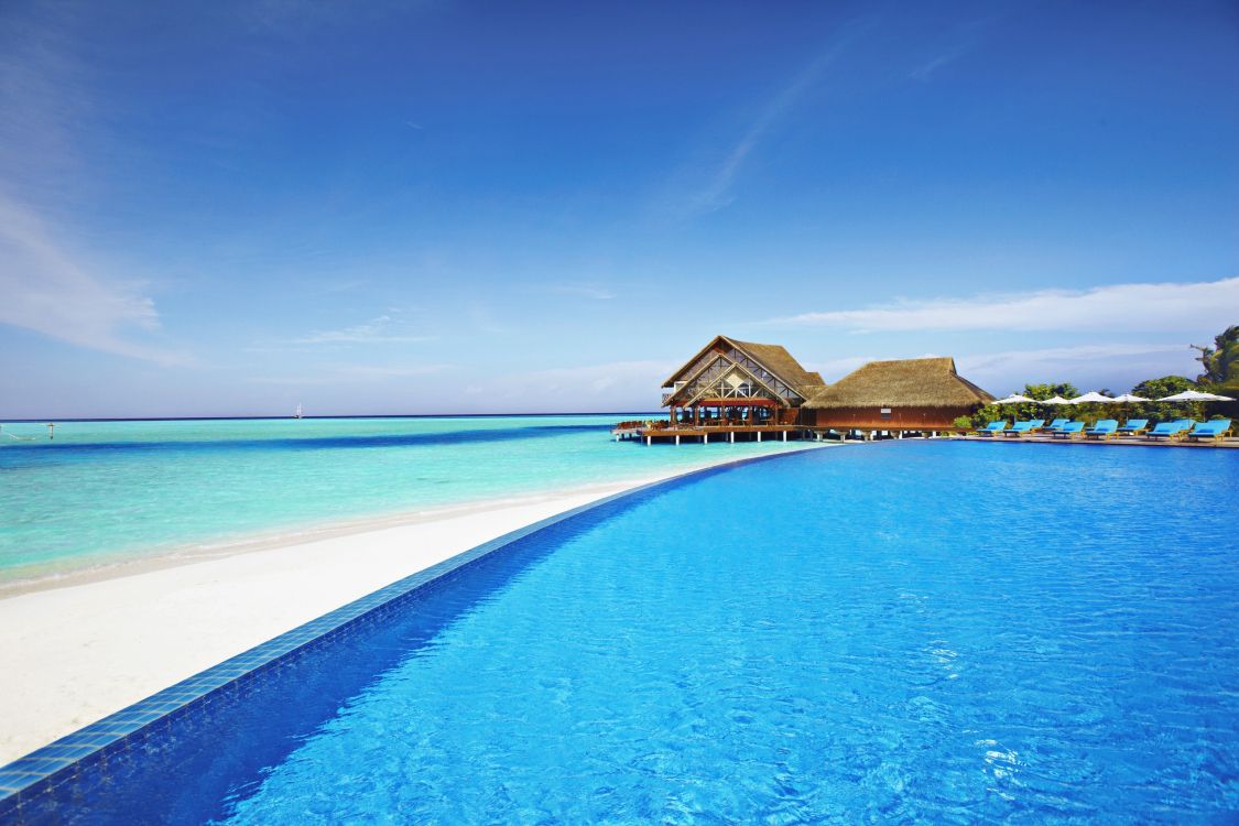 brown wooden house on blue sea under blue sky during daytime