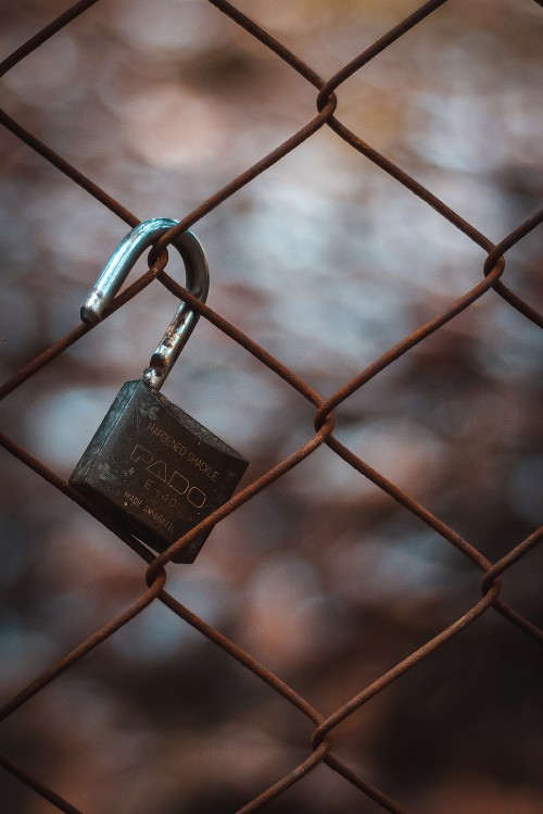 Image silver padlock on gray steel fence