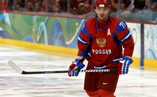 Image man in red and white jersey shirt holding black and white hockey stick