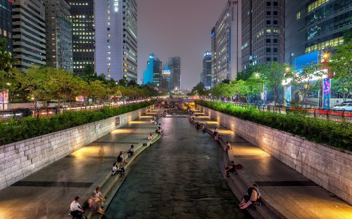 Image people walking on sidewalk near high rise buildings during night time