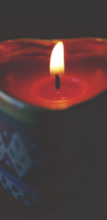 Image red lighted candle on blue round container