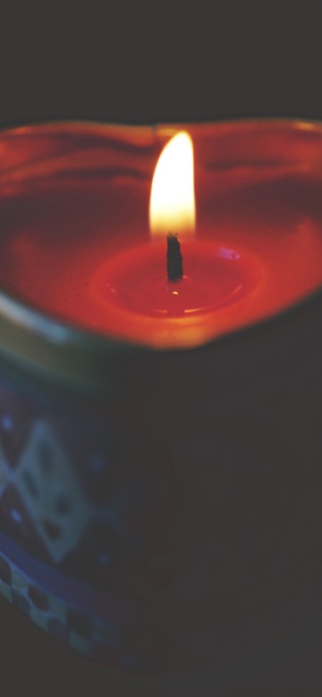 Image red lighted candle on blue round container