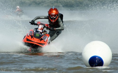 Image man riding red and black sports bike on water