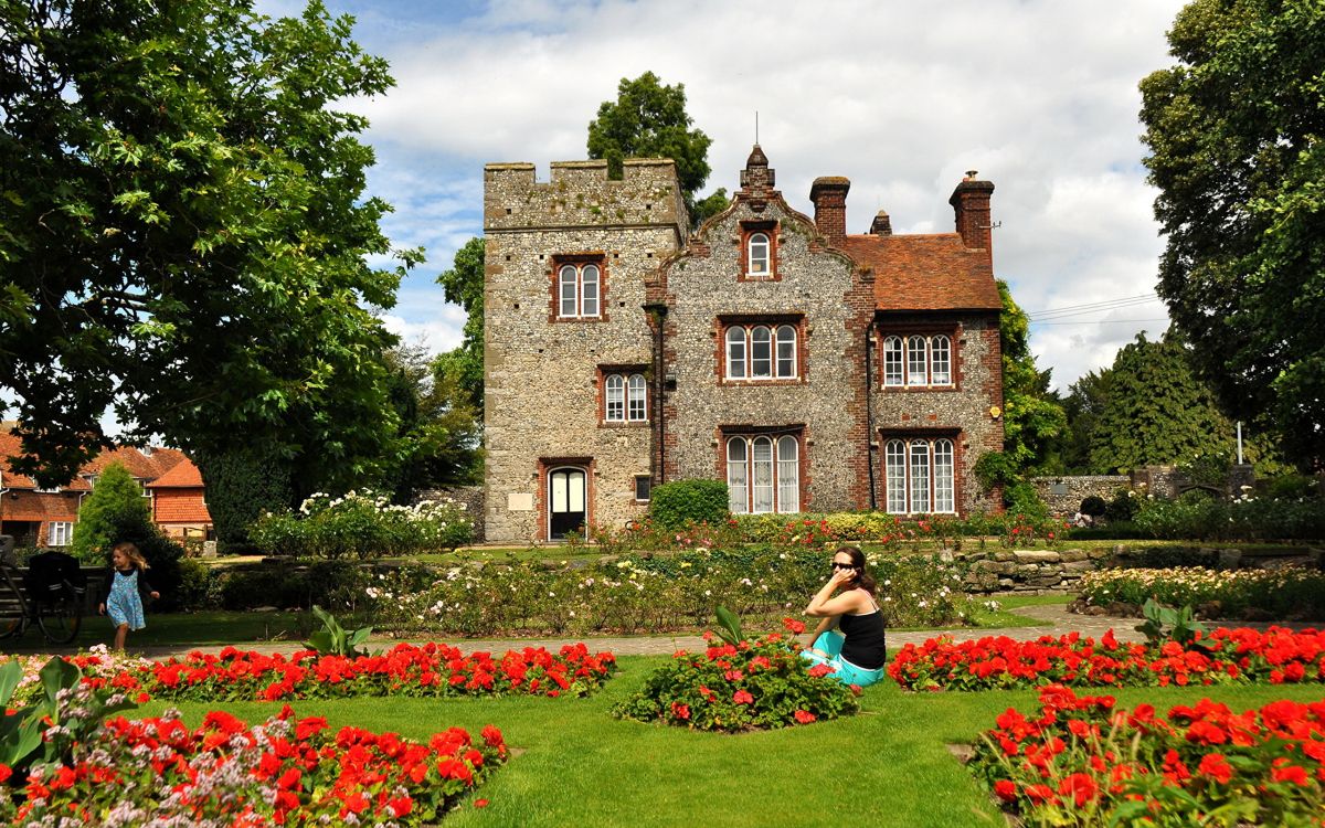 Femme en Chemise Noire Assise Sur un Terrain D'herbe Verte Près D'un Bâtiment en Béton Brun Pendant la Journée. Wallpaper in 2560x1600 Resolution