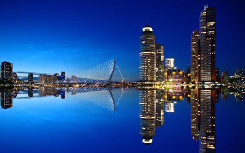 Image bridge over water near city buildings during night time