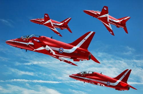 Image red jet plane in mid air during daytime