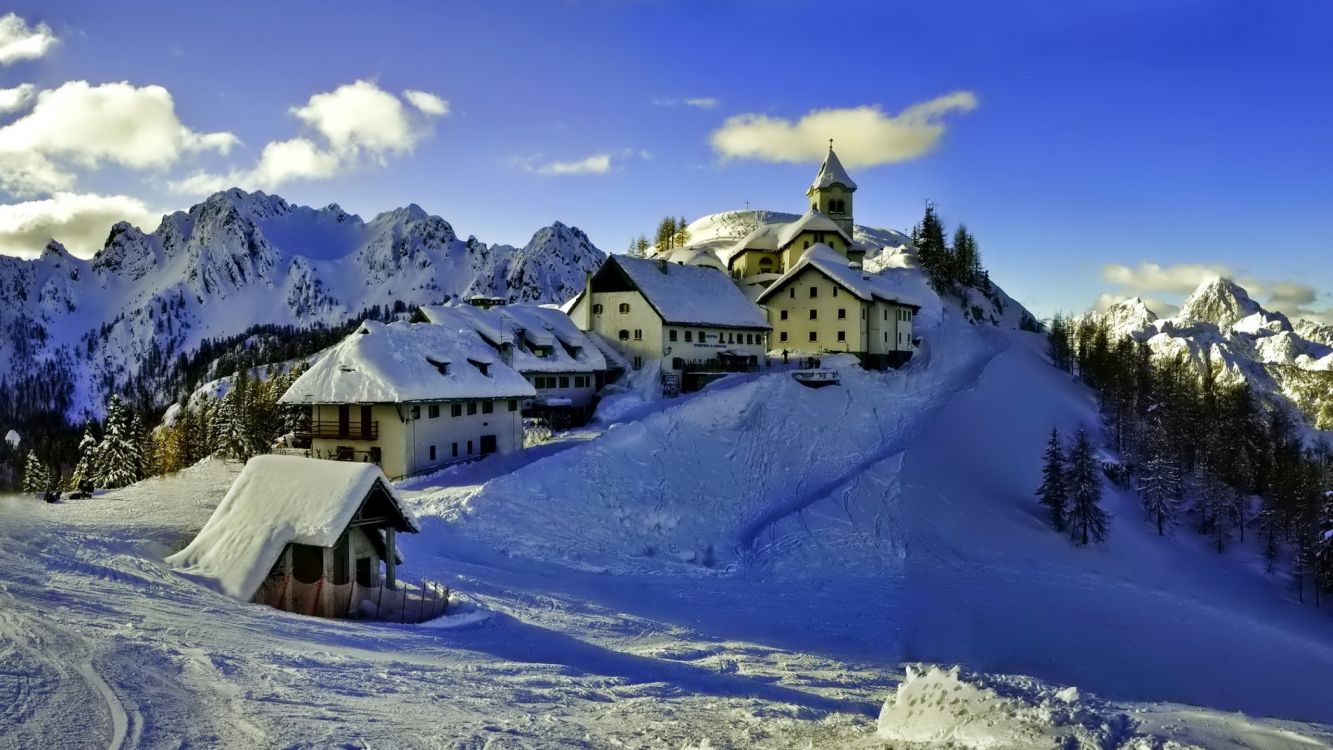 Weißes Und Braunes Haus Auf Schneebedecktem Berg Tagsüber. Wallpaper in 2560x1440 Resolution