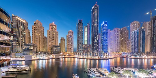 Image city skyline across body of water during night time