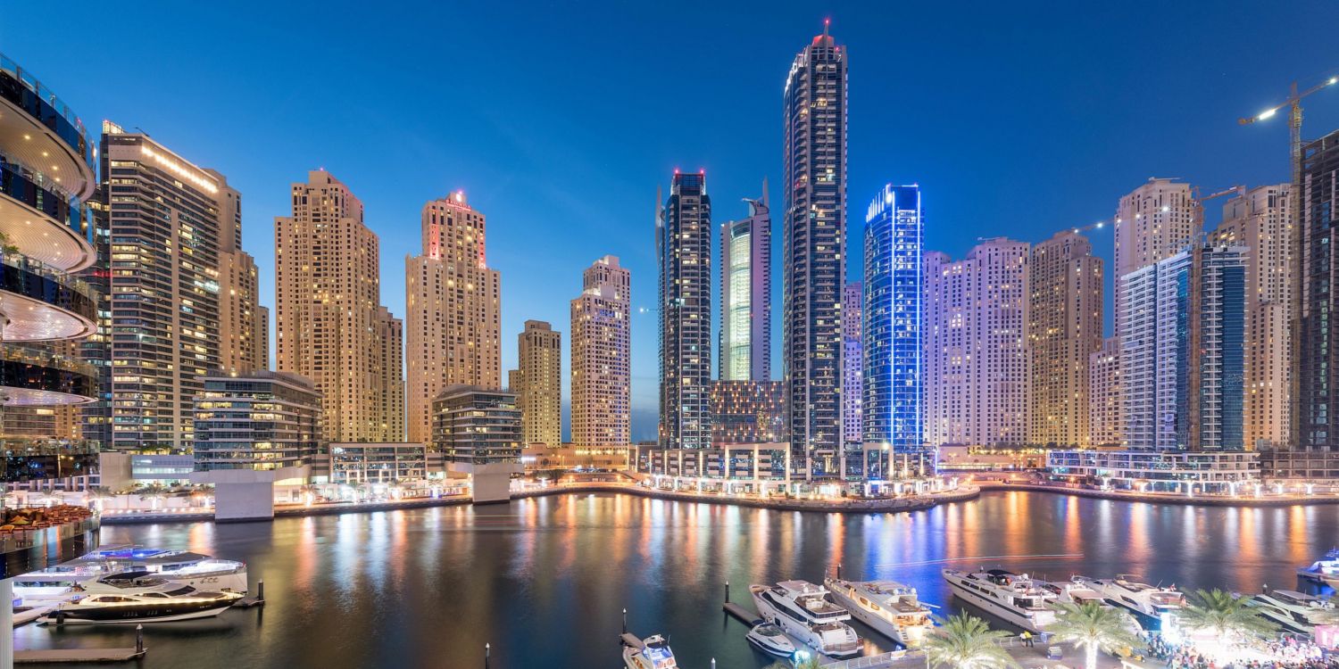 city skyline across body of water during night time