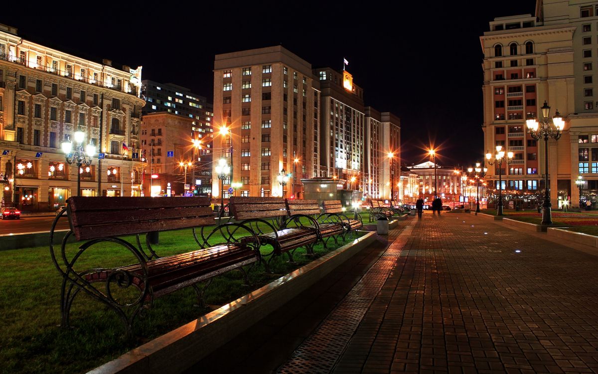 Leute, Die Nachts Auf Dem Bürgersteig in Der Nähe Eines Braunen Betongebäudes Gehen. Wallpaper in 2560x1600 Resolution