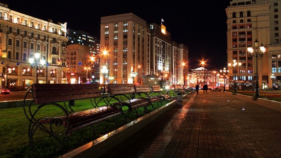 Image people walking on sidewalk near brown concrete building during night time