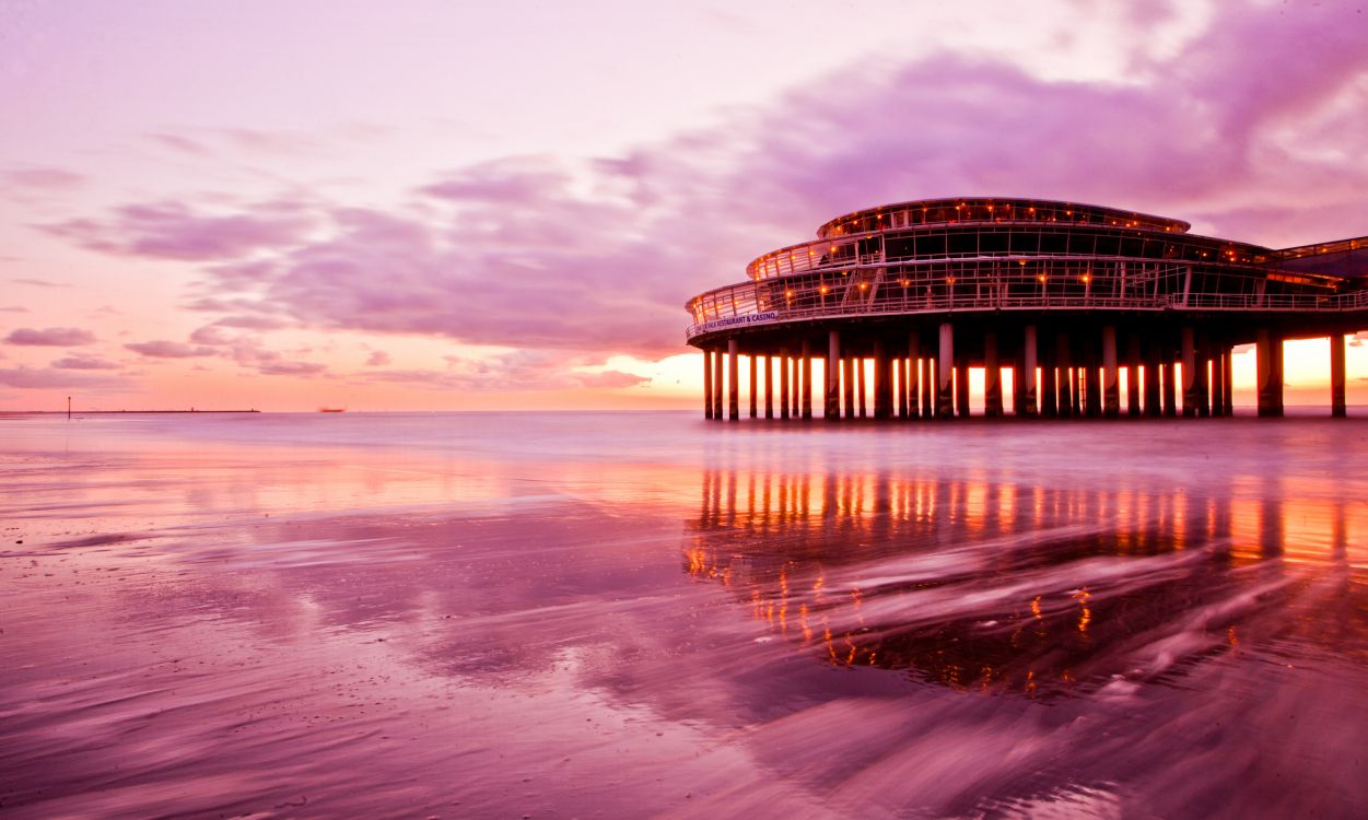 brown wooden dock on sea under white clouds during daytime