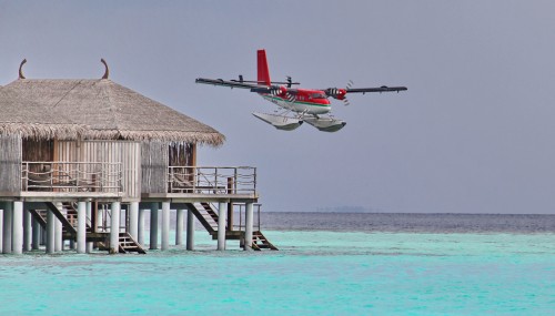 Image red and white plane flying over the sea during daytime