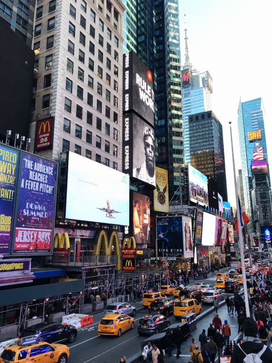 Voitures Sur Route Entre Les Immeubles de Grande Hauteur Pendant la Journée. Wallpaper in 3024x4032 Resolution