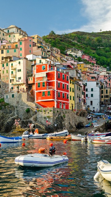 Image red and white boat on water near buildings during daytime