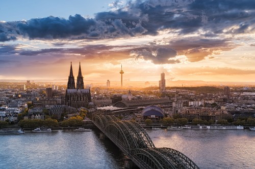 Image bridge over river near city buildings during sunset