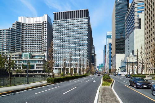 Image gray concrete road between high rise buildings during daytime