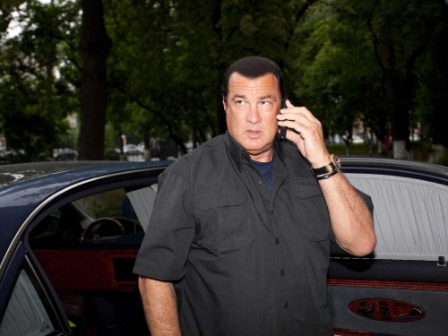 Image man in black button up shirt standing near red car during daytime