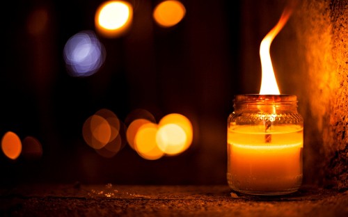 Image lighted candle in clear glass container