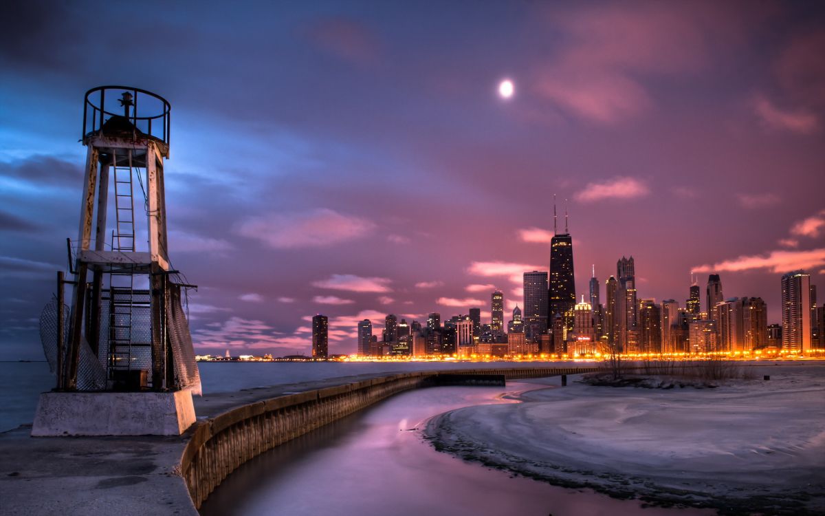 body of water near city buildings during night time