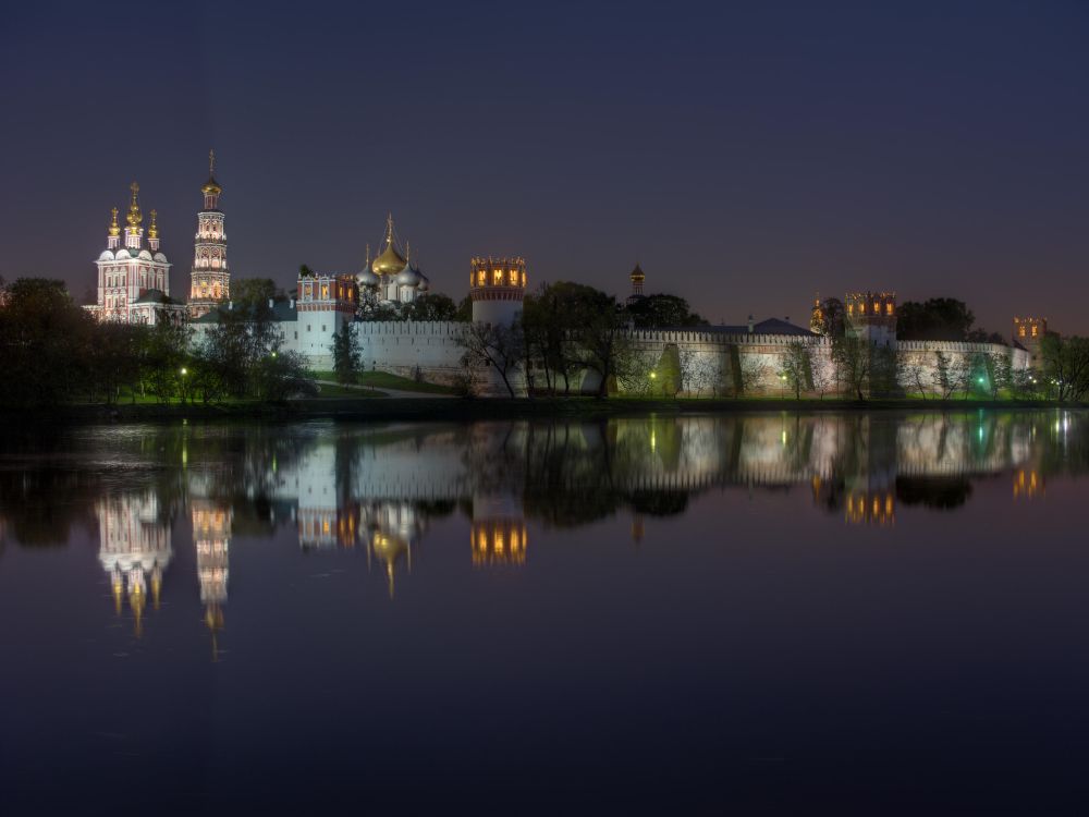 body of water near city buildings during night time