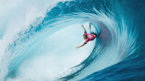 Image man in red wetsuit surfing on blue ocean water during daytime