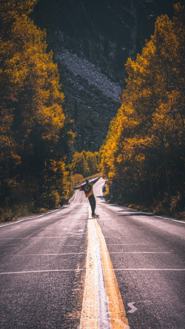 Image man in black jacket riding bicycle on gray asphalt road during daytime