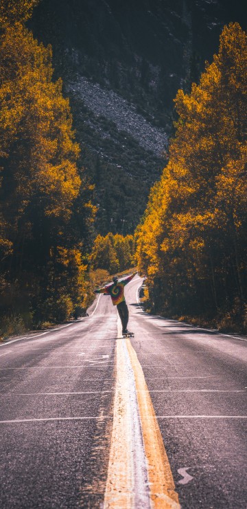 Image man in black jacket riding bicycle on gray asphalt road during daytime