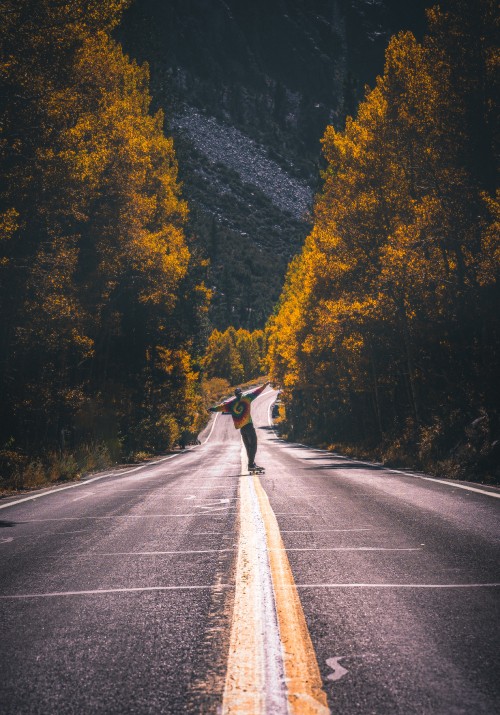 Image man in black jacket riding bicycle on gray asphalt road during daytime