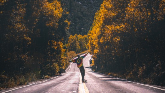 Image man in black jacket riding bicycle on gray asphalt road during daytime