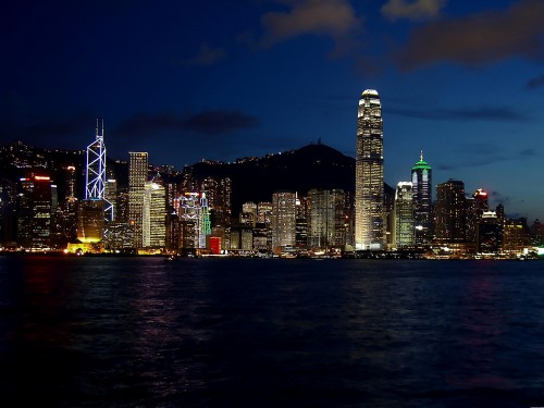 Image city skyline across body of water during night time