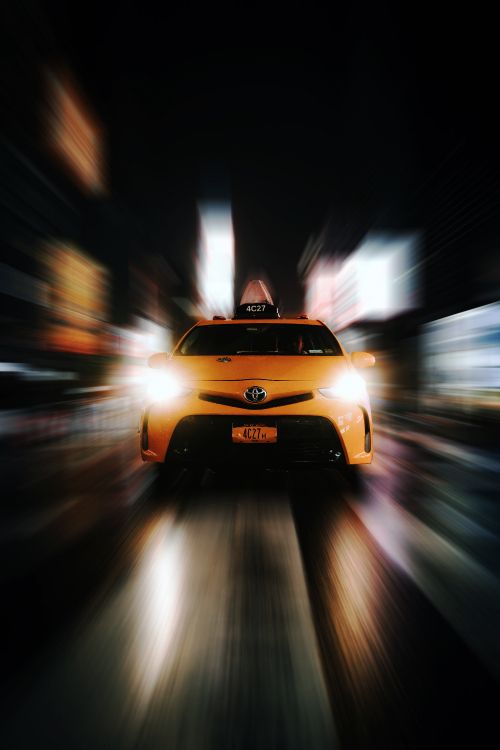 Gelbes Auto Auf Der Straße Während Der Nachtzeit. Wallpaper in 4000x6000 Resolution