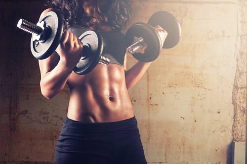 Image topless man in black shorts carrying black and silver dumbbell