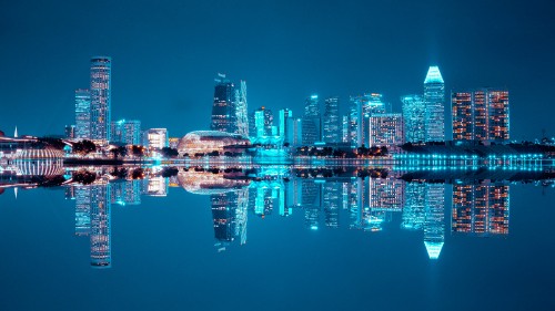 Image city skyline across body of water during night time