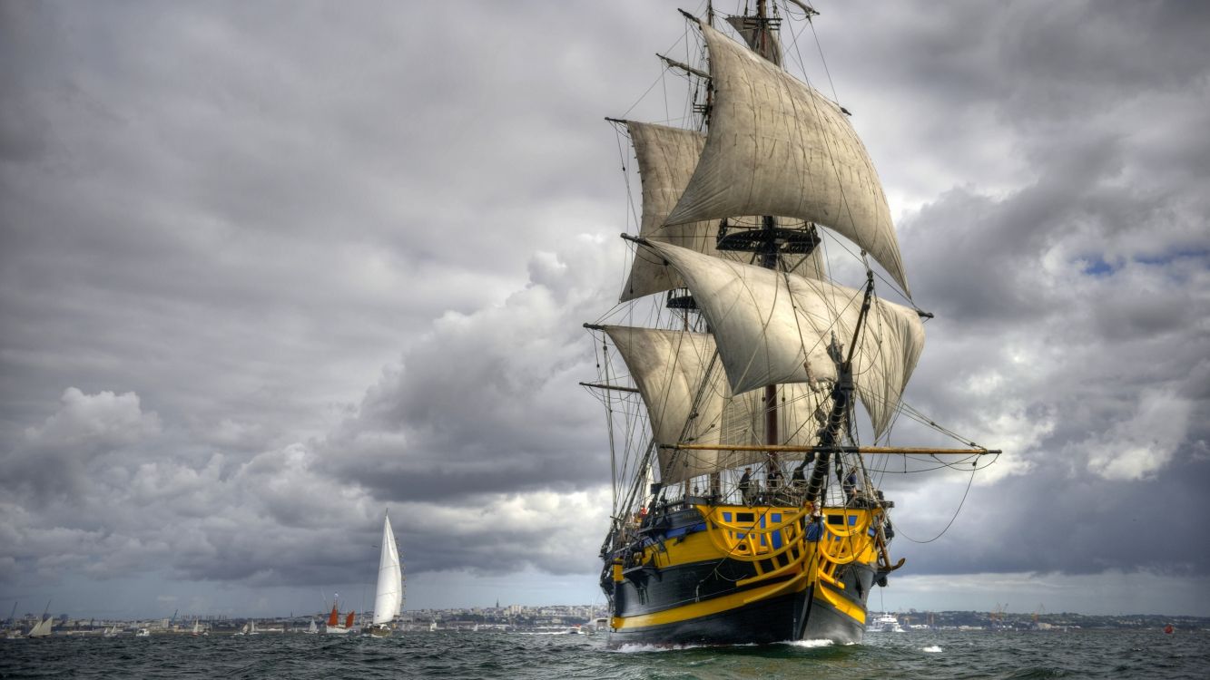 brown and white sail ship on sea under white clouds during daytime