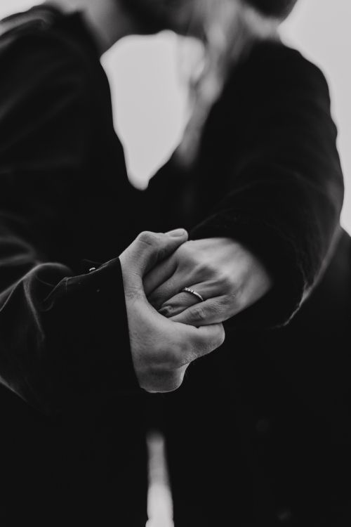 grayscale photo of person holding hands